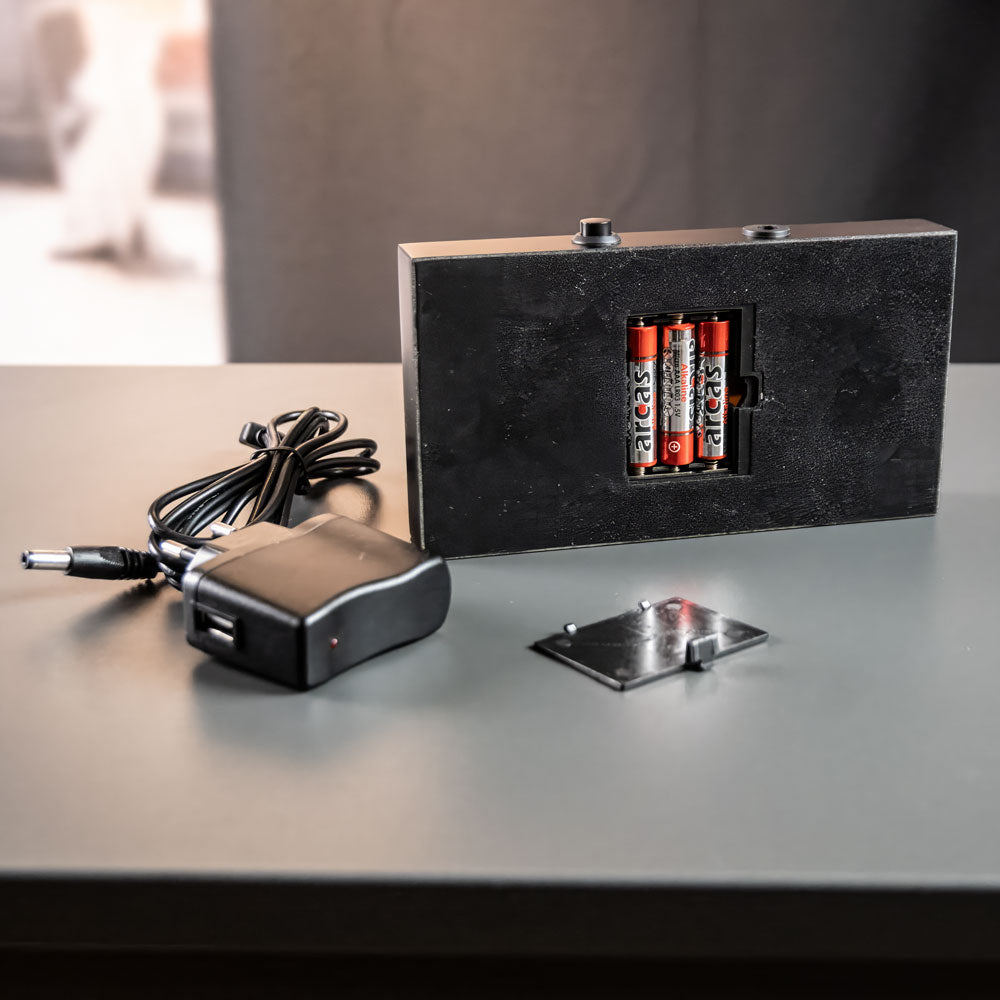 Baksida av lyxljusbas med öppet batterifack, AAA-batterier och strömadapter