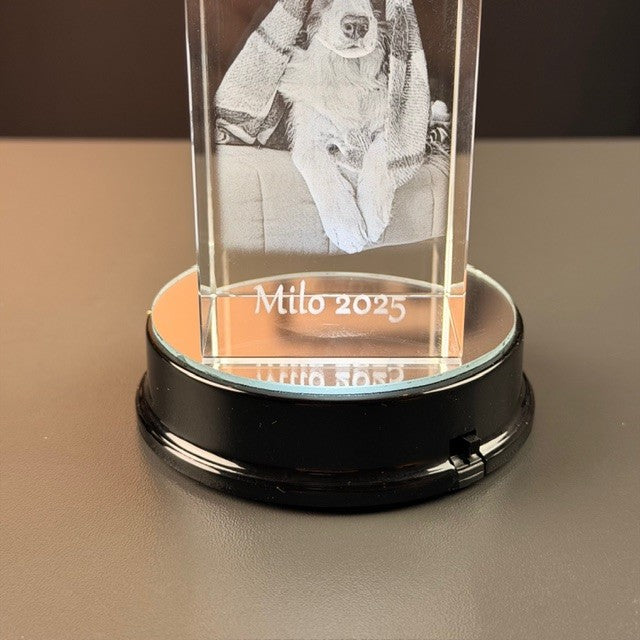 Svart rund batteriljusbas med glasblock med graverat foto och text