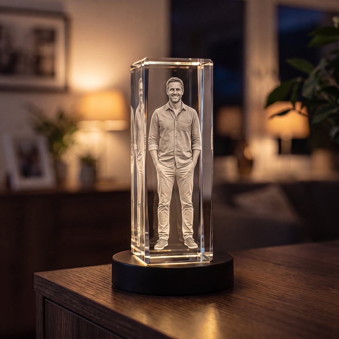 Hög glasblock med 3D-graverad stående man på svart ljusbas