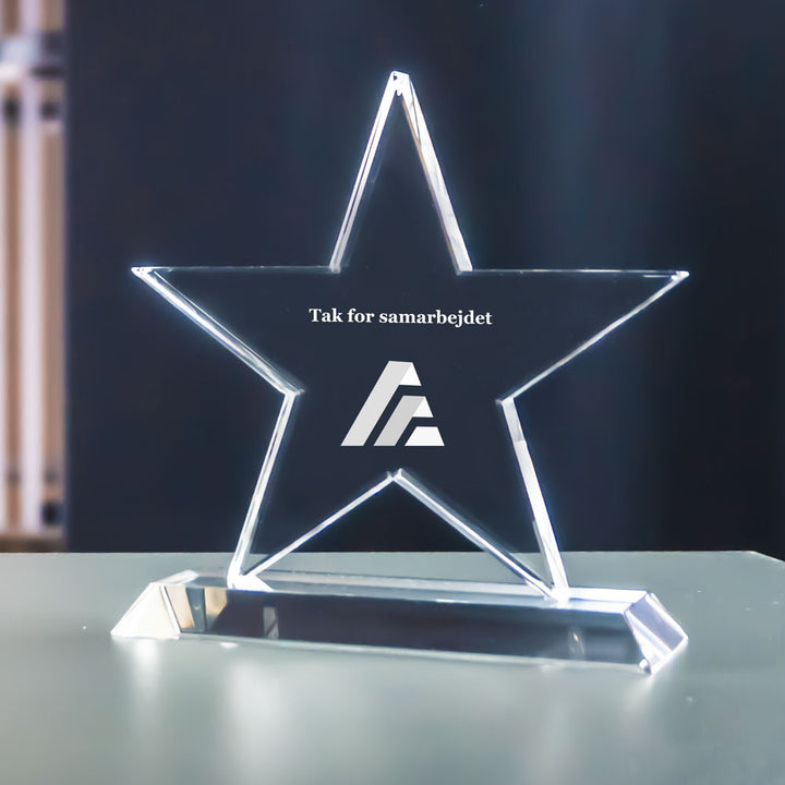 Stjärnformad award i kristallglas med lasergraverad logga och text
