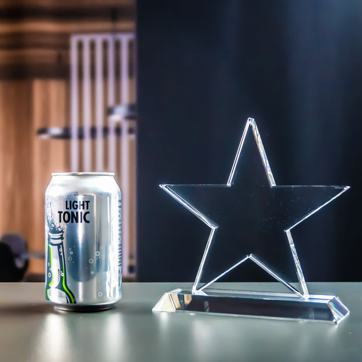 Stjärn-award i kristallglas bredvid en burk för storlek