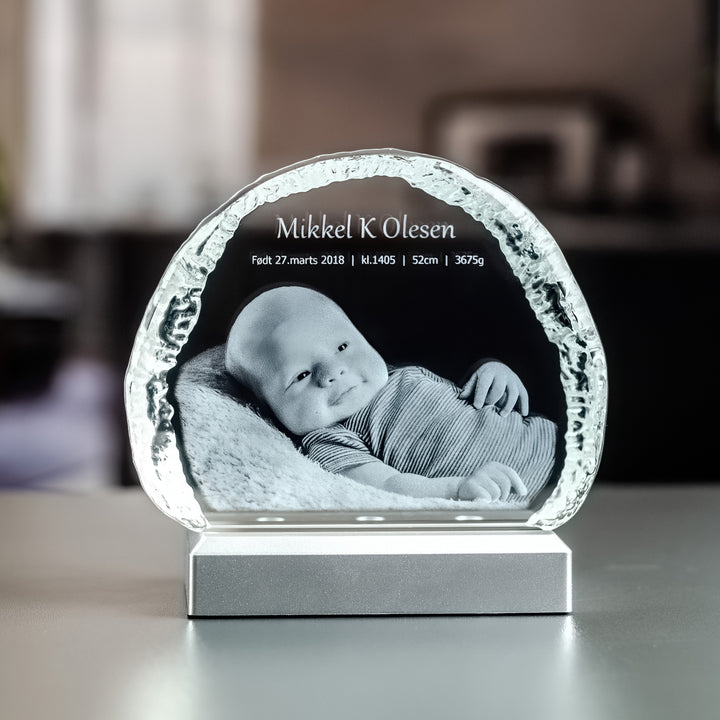 Liten isbergsformad glasblock med 3D-graverad nyfödd bebis och namn på ljusbas