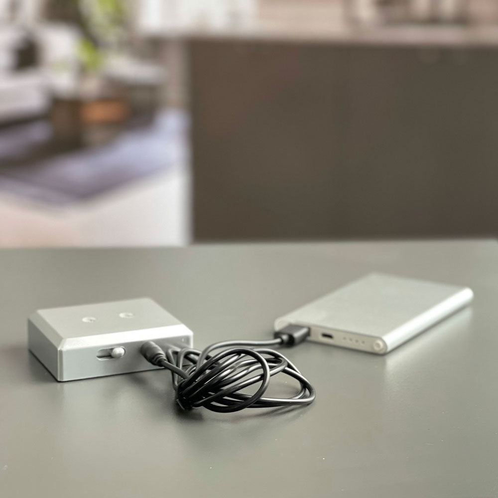 Strömadapter och två ljusa batteriljusbaser i metall