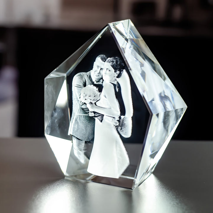 Hög isbergsformad glasblock med brudpar sett snett, så att de facettslipade kanterna syns